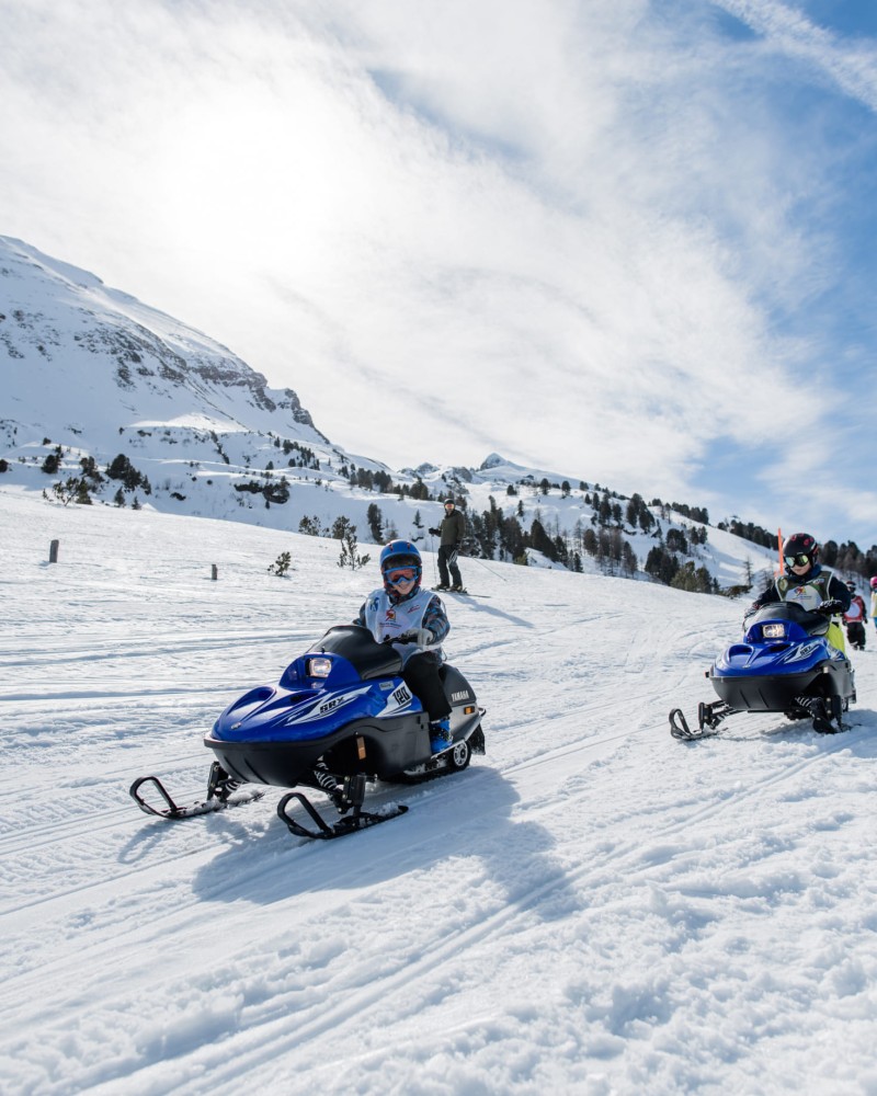 Kids beim Skidoo fahren im Schnee