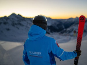 Skier at sunset with ski in hand